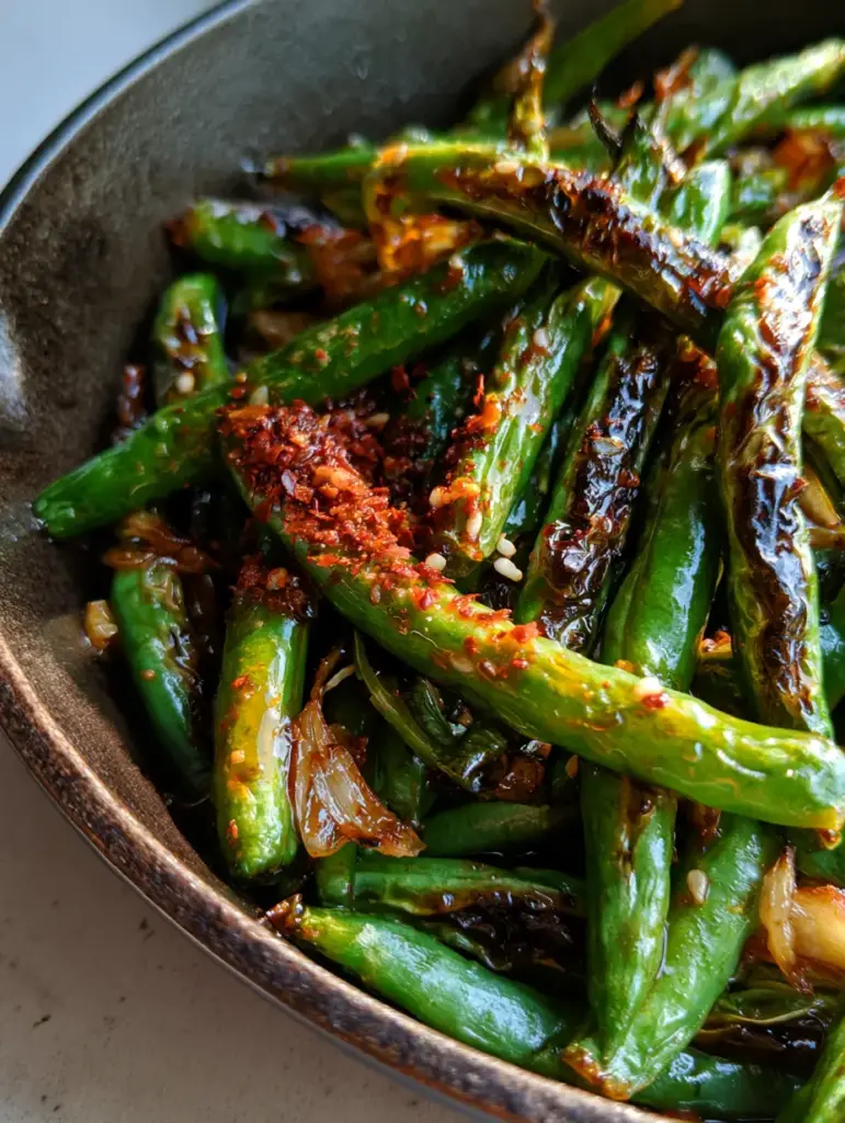 Garlic Chili Green Beans: The Ultimate Blistered Skillet Side Dish 1 Vibrant emerald green beans coated in garlic chili oil with toasted sesame seeds and red pepper flakes.