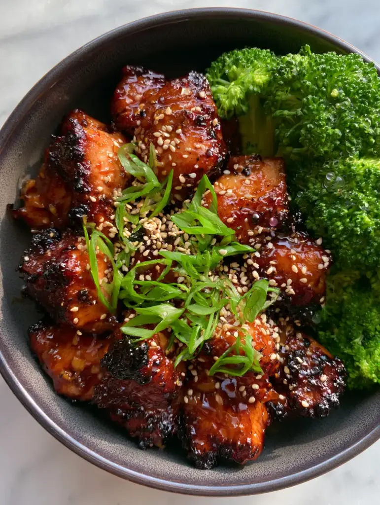 Paleo Chicken Teriyaki with Sticky Ginger-Garlic Glaze 1 Close-up of crispy-edged chicken thigh pieces drenched in a high-shine Paleo teriyaki glaze with sesame seeds.