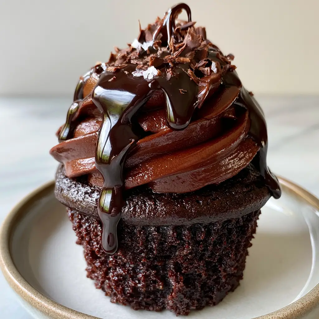 Chocolate Cupcakes with Glossy Buttercream and Dark Chocolate Fudge 1 A smartphone photo featuring a chocolate cupcake with a thick glossy frosting swirl and a slow-running fudge drizzle sprinkled with sea salt.